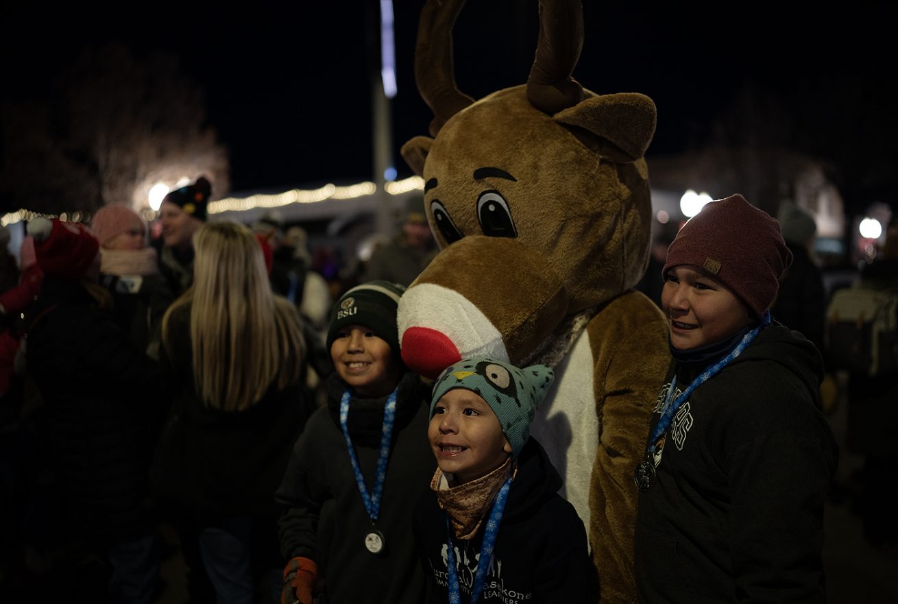 Kids pose for a photo with Rudolph The Red Nosed Reindeer.